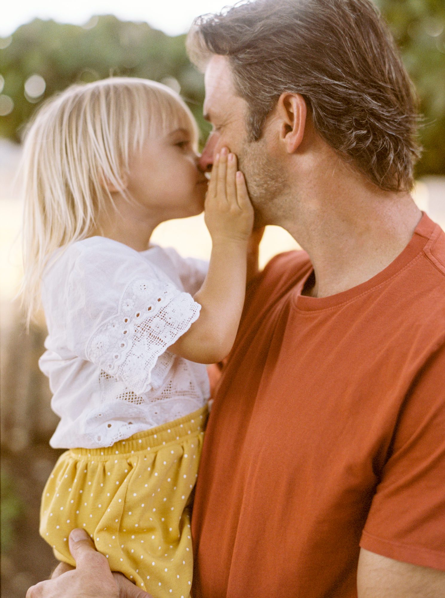 Daughter giving dad a kiss