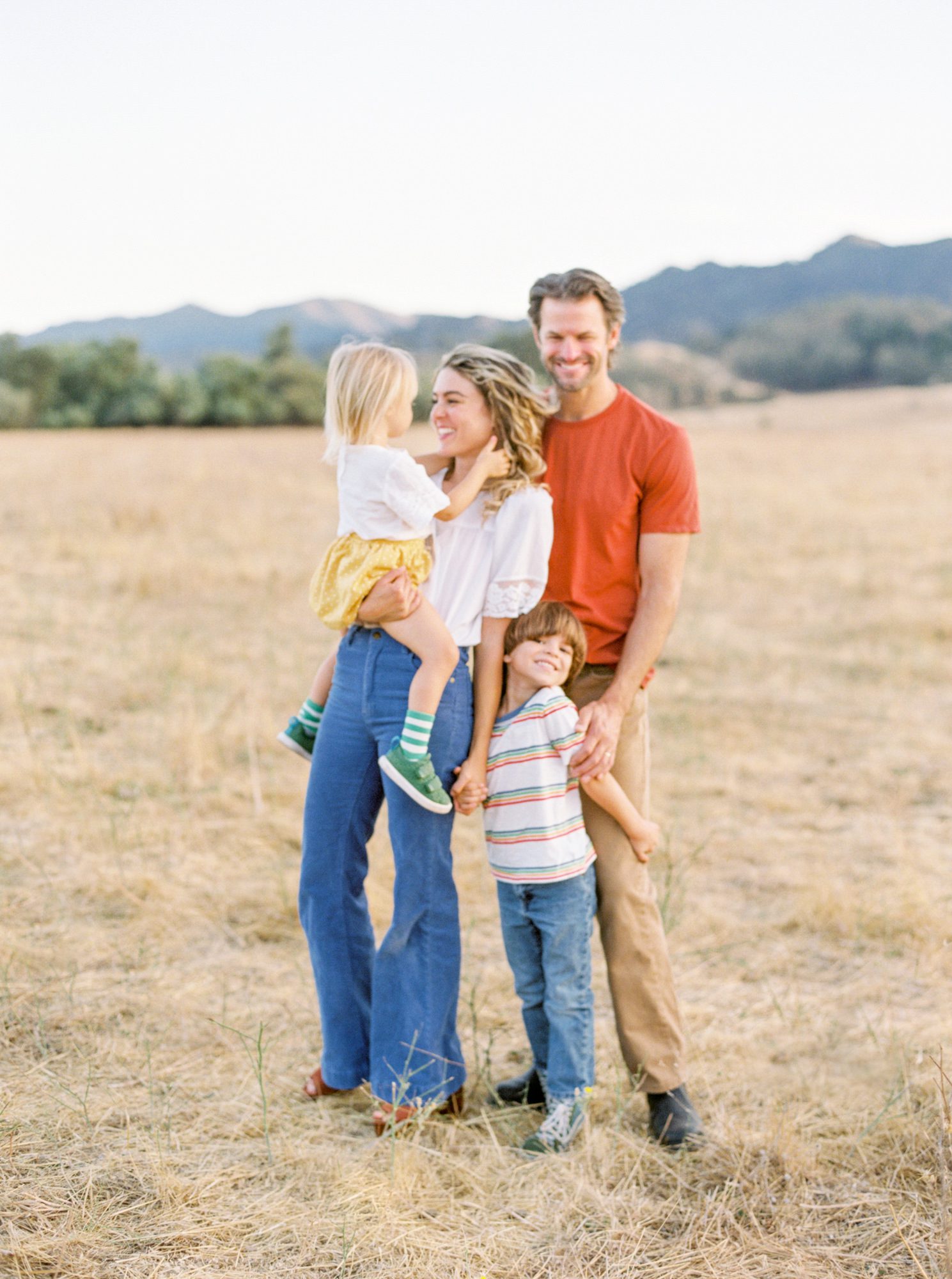 Candid family photo of a family in a field